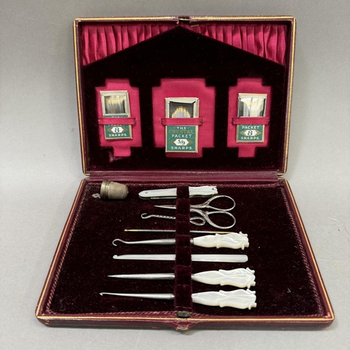 8 - A ladies cased sewing kit with mother of pearl handles comprising scissors, sewing implements and pa... 