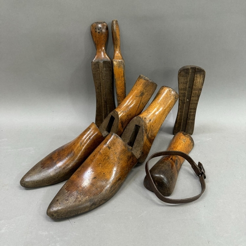 23 - A pair of carved wooden treen adjustable shoe lasts, held together with leather belt