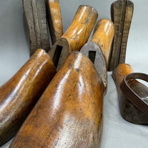 23 - A pair of carved wooden treen adjustable shoe lasts, held together with leather belt