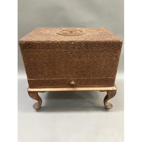 163 - An Indonesian/Balinese heavily carved sewing box on legs with fitted interior, 45cm x 42cm