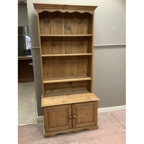 84 - A pine open fronted bookcase cupboard, with three shelves above two doors on plinth base, 91cm wide