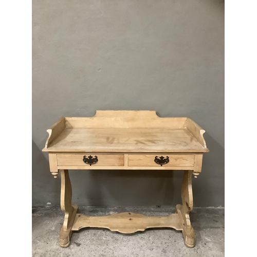 95 - A pine wash stand, having carved back panel, two drawers on single carved stretcher, 96.5cm wide