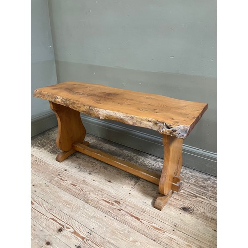 100 - A pine rough hewn bench with single stretcher, 102cm wide