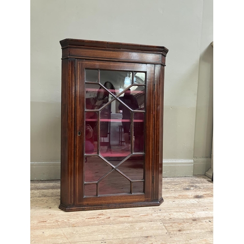 80 - An Edwardian mahogany crossbanded hanging corner cupboard with single glazed tracery door