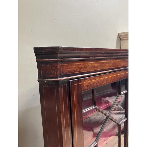 80 - An Edwardian mahogany crossbanded hanging corner cupboard with single glazed tracery door