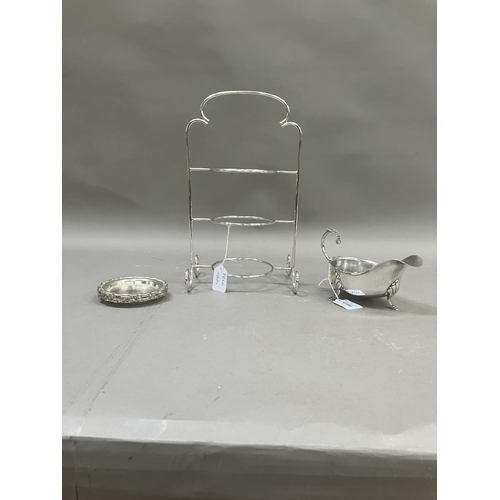 123B - An EPNS three tier cake stand with curled feet, 23cm high, together with an EPNS sauceboat on three ... 