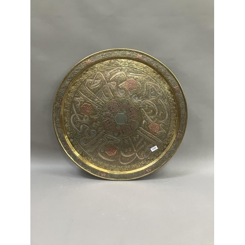 238 - A large brass tray, inlaid with copper, etched with Arabic text 72cm diameter