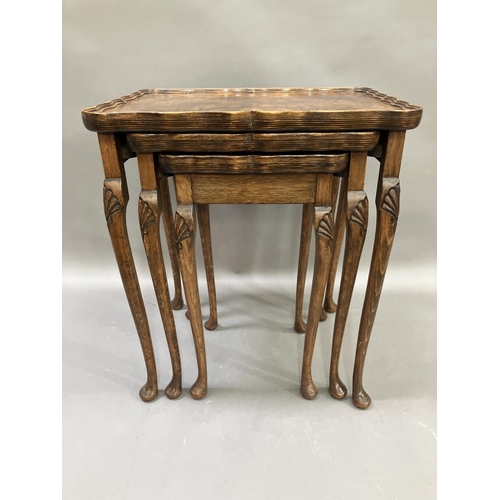 303 - An oak and walnut nest of three tables, the cabriole legs carved with shells to the knees, 56cm high