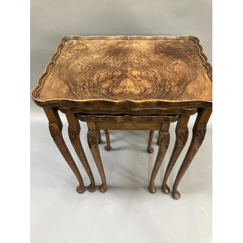 303 - An oak and walnut nest of three tables, the cabriole legs carved with shells to the knees, 56cm high