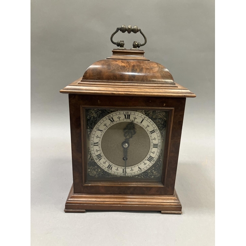 206 - An early 20th century figured walnut bracket clock, having a pagoda top with carrying handle, brass ... 