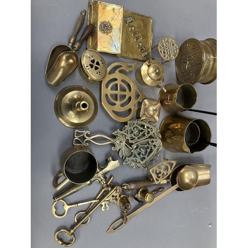 254 - A collection of brass comprising pans, bells, trivets, a wall pocket, shovels etc