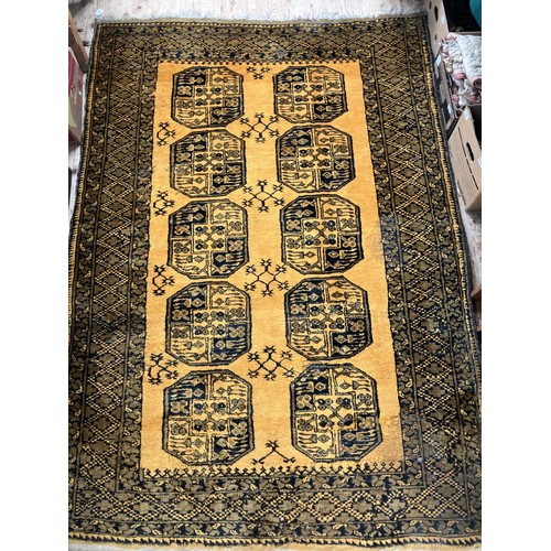 309 - An Afghan Ersari rug, hand-knotted, having two bands of medallions on a gold field within a geometri... 