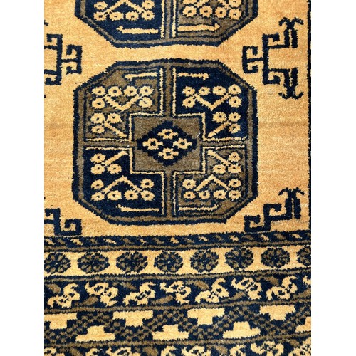 309 - An Afghan Ersari rug, hand-knotted, having two bands of medallions on a gold field within a geometri... 