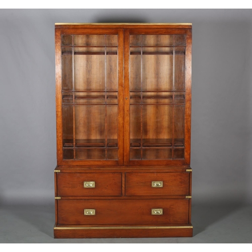 94 - Kennedy of Ipswich, a walnut and brass bound campaign bookcase-chest retailed by Harrods, having two... 