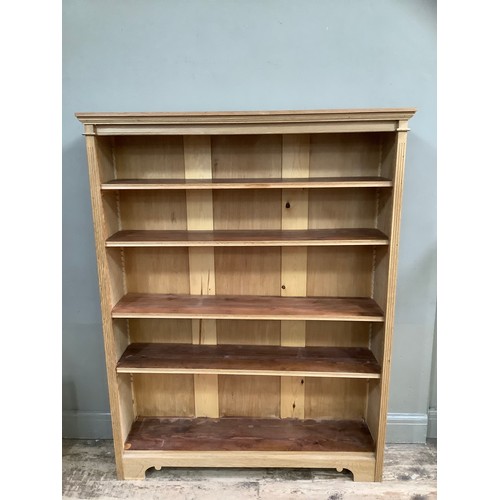 291 - An oak open bookcase having a moulded cornice above four adjustable shelves, on bracket feet, 120cm ... 