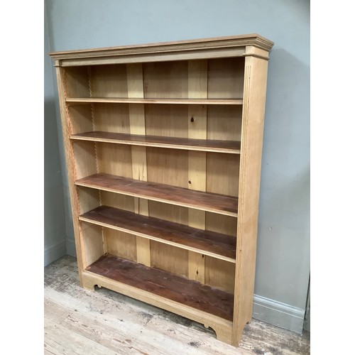 291 - An oak open bookcase having a moulded cornice above four adjustable shelves, on bracket feet, 120cm ... 