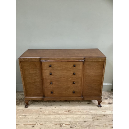 265 - A mid 20th Century walnut sideboard having a central bank of four drawers flanked by two doors on ca... 