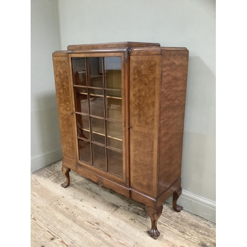 266 - A mid 20th Century walnut cabinet having a glaze door to the centre fitted with three internal shelv... 