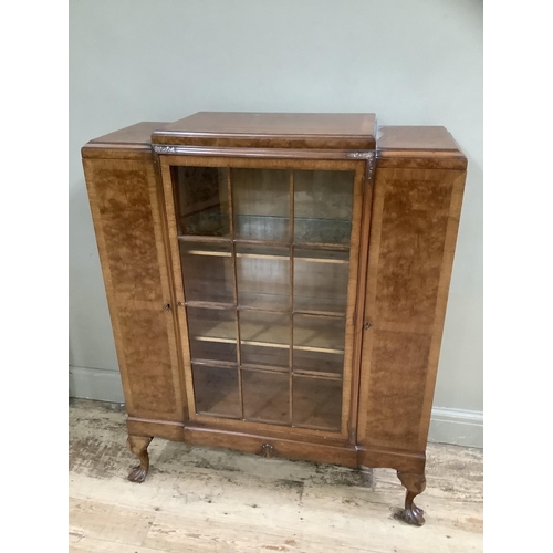 266 - A mid 20th Century walnut cabinet having a glaze door to the centre fitted with three internal shelv... 