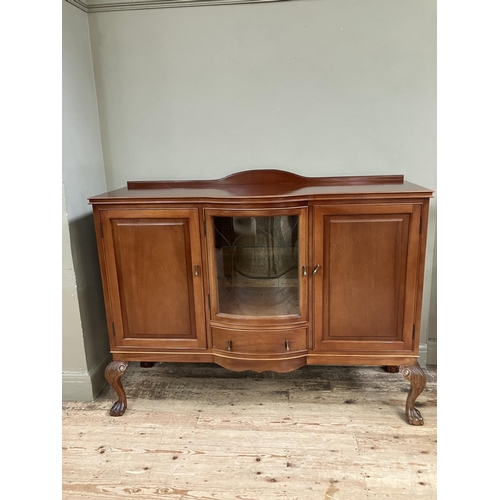 292 - A mahogany semi bow front sideboard, having a short raised back, the central glazed door fitted with... 