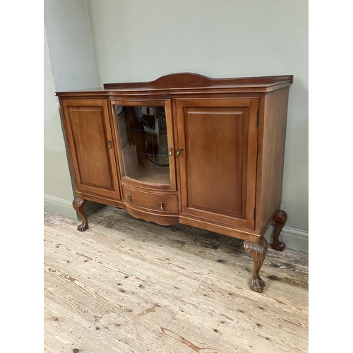 292 - A mahogany semi bow front sideboard, having a short raised back, the central glazed door fitted with... 