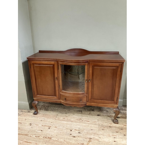 292 - A mahogany semi bow front sideboard, having a short raised back, the central glazed door fitted with... 