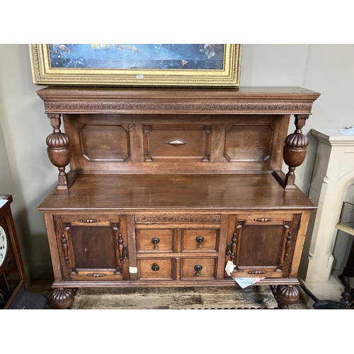 270 - An oak court cupboard with raised back having a carved frieze on baluster supports above a bank of f... 