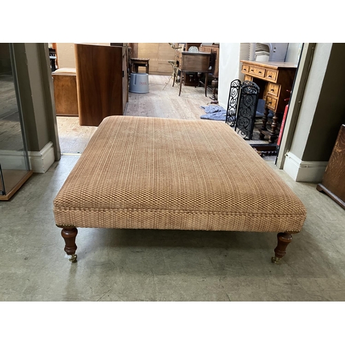 277 - A stool having turned mahogany legs on brass castors upholstered in burnt umber fabric