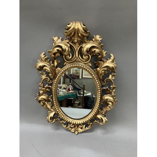 295 - A gilt oval wall mirror, heavily moulded frame formed of acanthus leaves and bead work, 46cm high