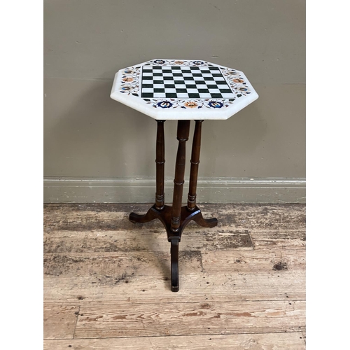 315 - A Pietra Dura games table of octagonal outline on a three column tripod pedestal base, 41cm diameter