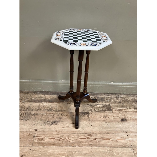 315 - A Pietra Dura games table of octagonal outline on a three column tripod pedestal base, 41cm diameter