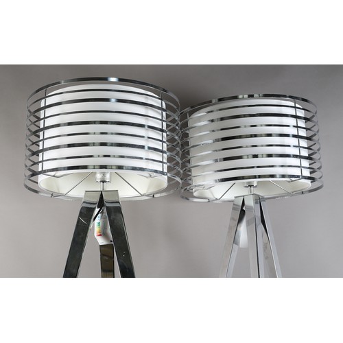 73 - A pair of polished metal floor lamps, by CIMC Home, pierced drum heads with internal off-white shade... 