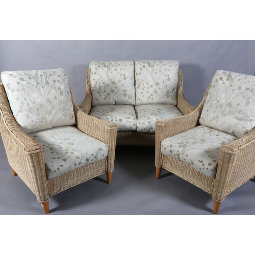 124 - A three piece wicker two seater sofa and pair of armchairs, the seat and back cushions upholstered i... 