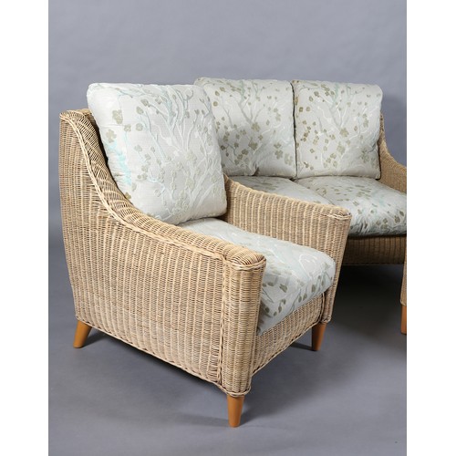 124 - A three piece wicker two seater sofa and pair of armchairs, the seat and back cushions upholstered i... 