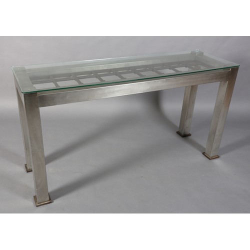 123 - A matt stainless steel console, rectangular, inset with a cast iron open grid, with glass surface 16... 