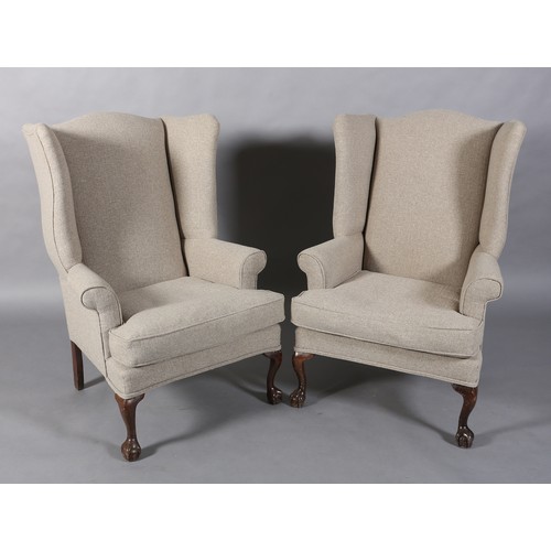 97 - A pair of winged armchairs upholstered in mid grey fabric, on mahogany cabriole legs with claw on ba... 