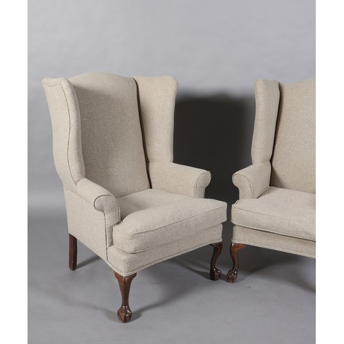 97 - A pair of winged armchairs upholstered in mid grey fabric, on mahogany cabriole legs with claw on ba... 