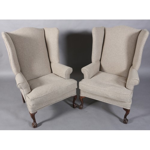 97 - A pair of winged armchairs upholstered in mid grey fabric, on mahogany cabriole legs with claw on ba... 