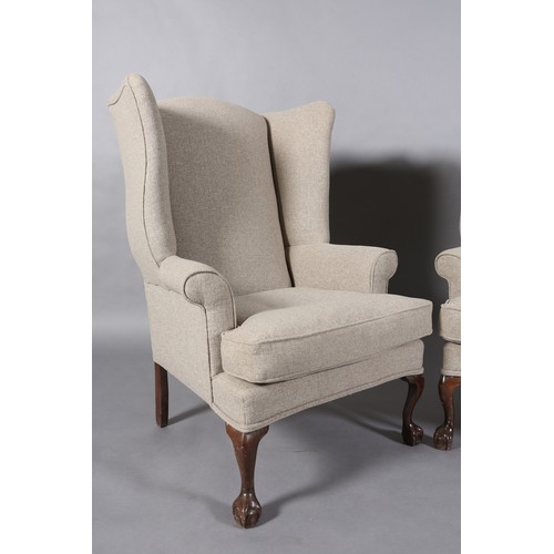 97 - A pair of winged armchairs upholstered in mid grey fabric, on mahogany cabriole legs with claw on ba... 