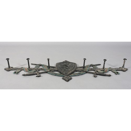 127 - A Victorian cast iron Scottish Baronial hat and coat rack formed as crossed swords and riband motto ... 