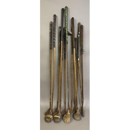 464 - A collection of early 20th century golf clubs with hickory shafts, including irons and woods, 13 in ... 