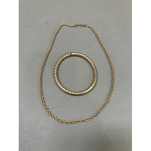 273 - A stiff hinged bangle in 9ct gold in full platted pattern together with a  9ct neck chain of hollow ... 