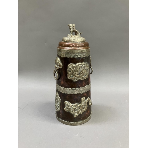 14 - A Tibetan copper container of tapered form, with applied metal mounts of dragons, the cover having a... 