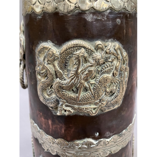 14 - A Tibetan copper container of tapered form, with applied metal mounts of dragons, the cover having a... 