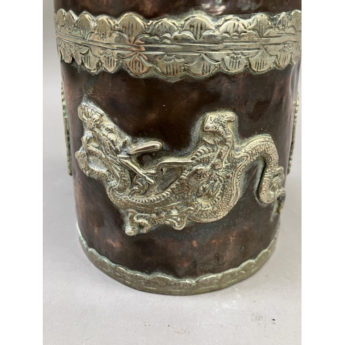 14 - A Tibetan copper container of tapered form, with applied metal mounts of dragons, the cover having a... 