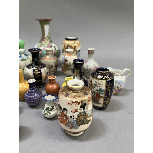 229 - A Chinese famille rose bottle neck vase, 12cm high together with a collection of 23 miniature vases ... 