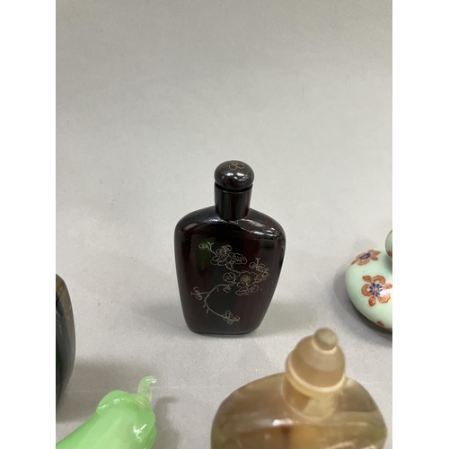 214 - A collection of eleven modern Chinese snuff bottles, in porcelain, agate etc