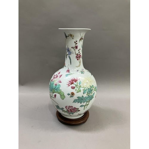 54 - A Chinese famille rose bottle neck vase, having a bulbous body and flared neck, painted with flowers... 