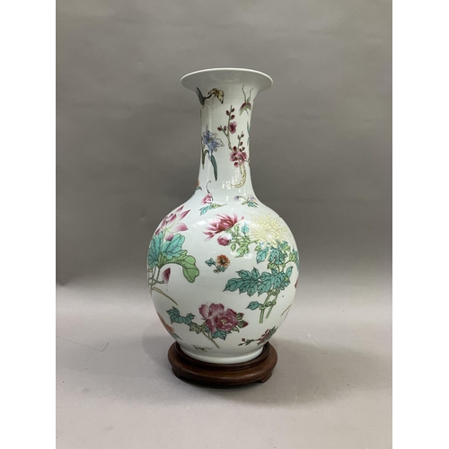 54 - A Chinese famille rose bottle neck vase, having a bulbous body and flared neck, painted with flowers... 