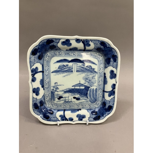 24 - A Japanese Arita dish, square outline painted to the centre in under glazed blue with island pavilio... 